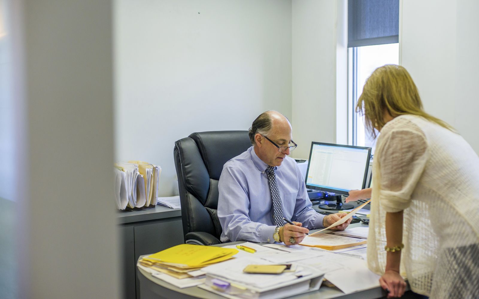 Reviewing revenue-cycle paperwork with an office worker